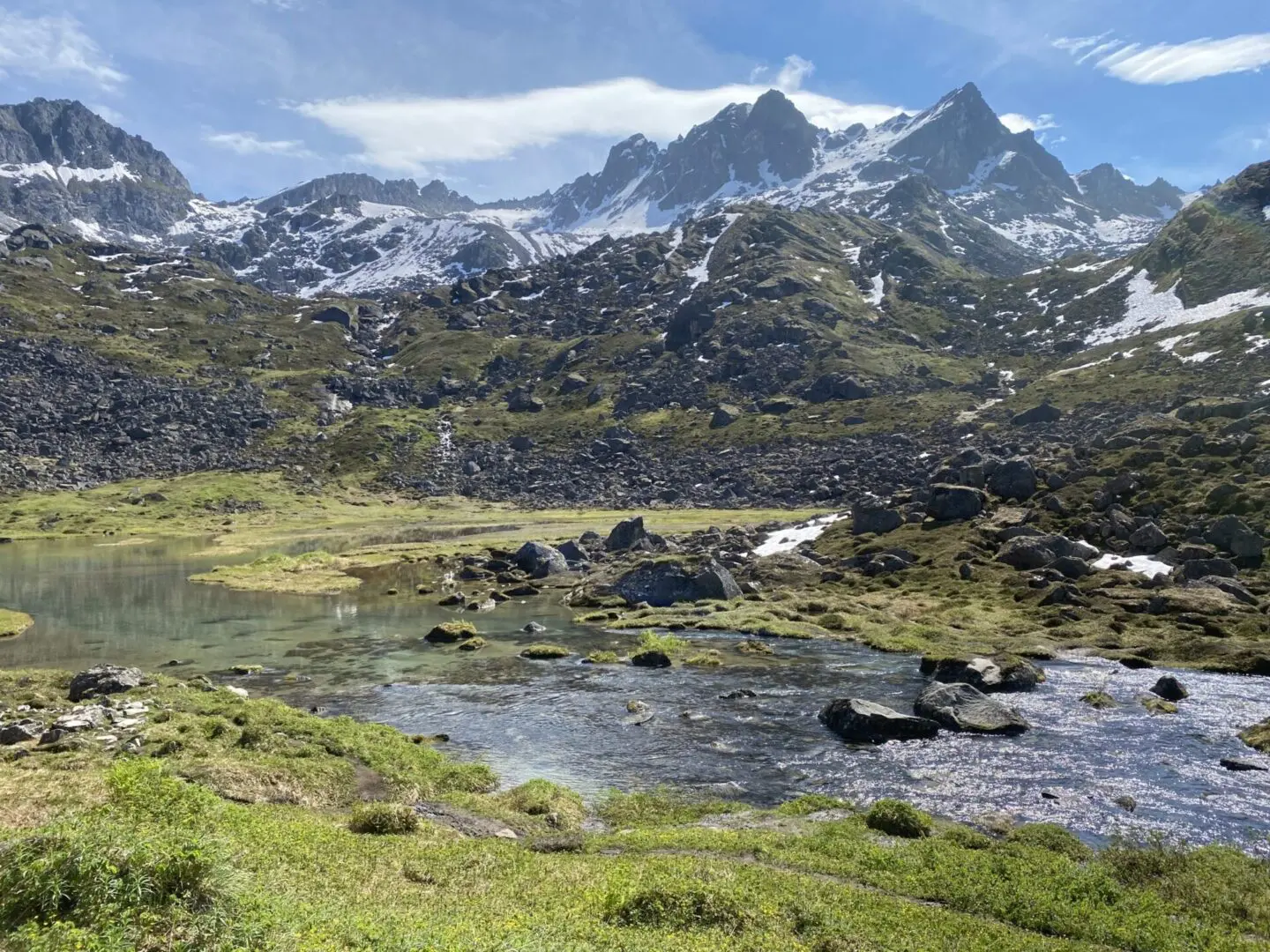 A lake in the mountains with mountains in the background.