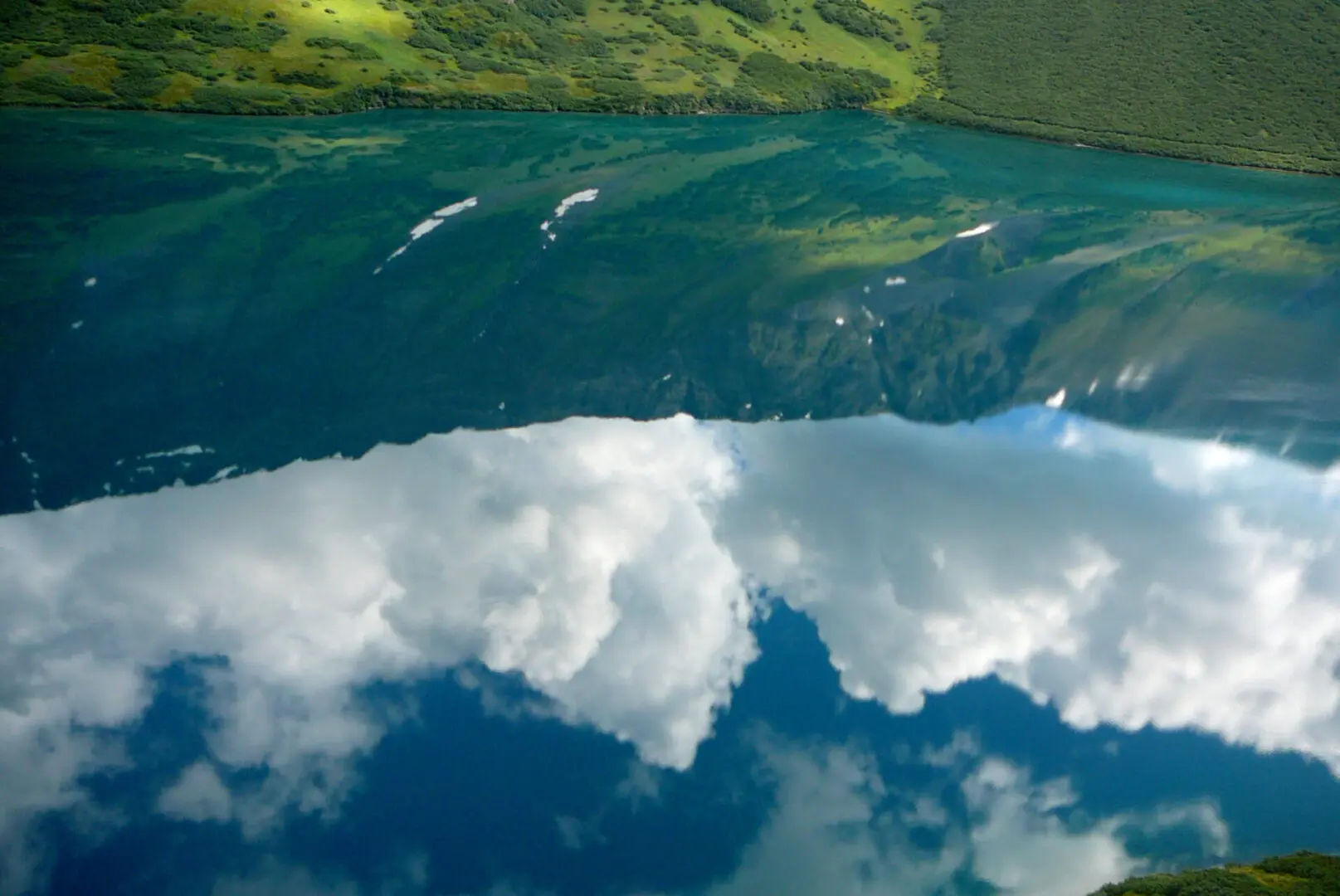 A lake with clouds reflected in it.