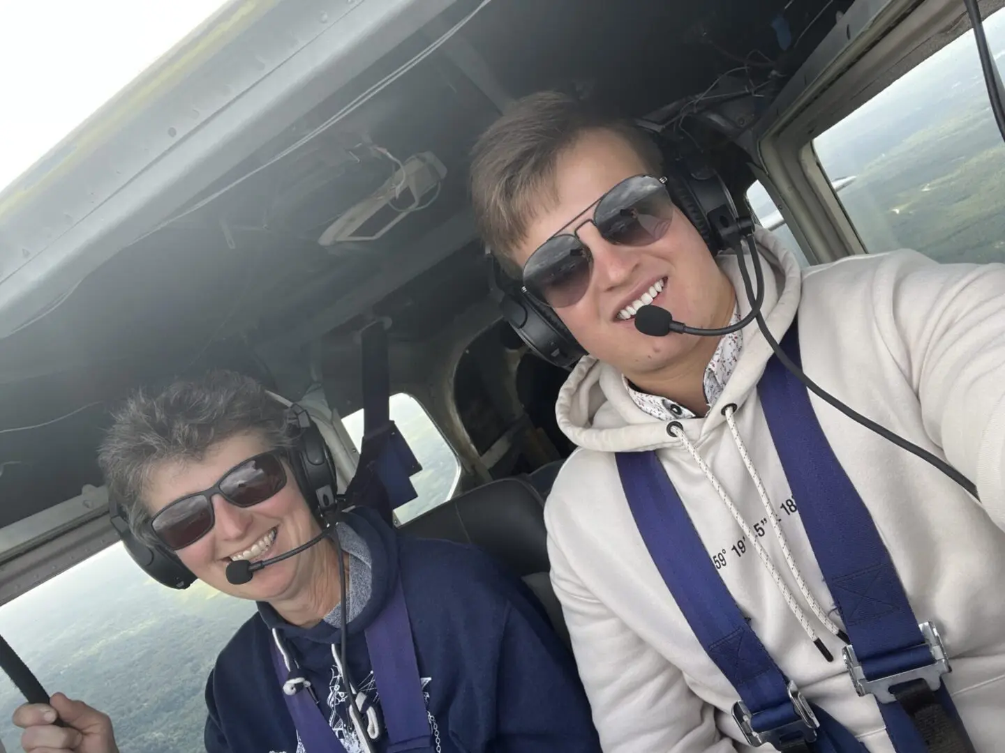 Two people sitting in the cockpit of a plane.