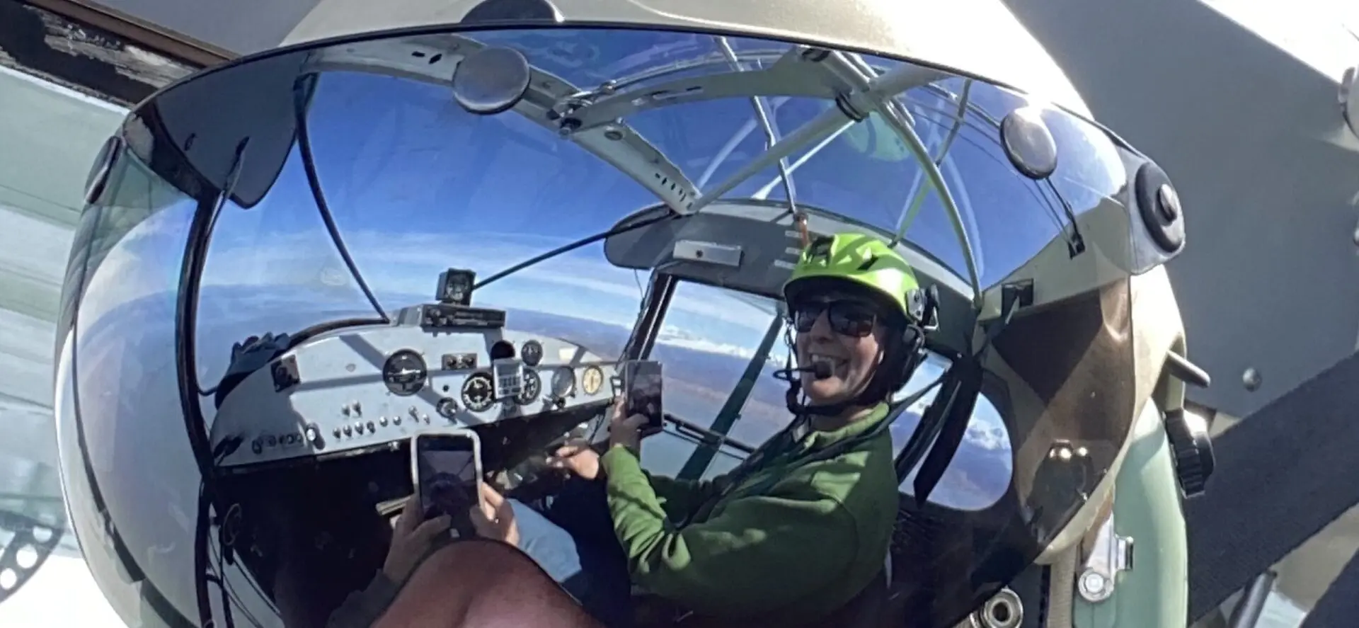 A man wearing a helmet in the cockpit of a plane.