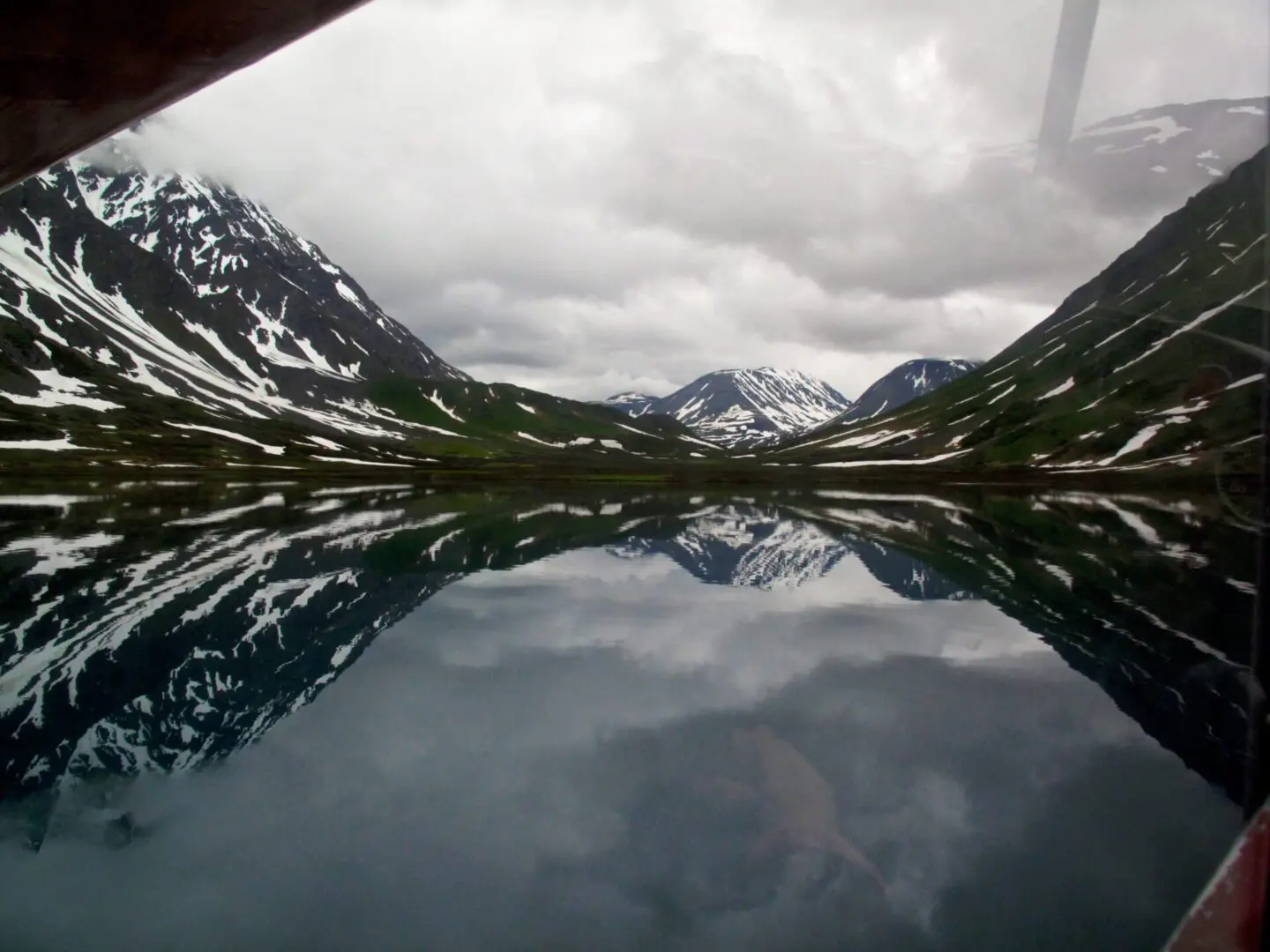 A view of a lake with mountains reflected in it.