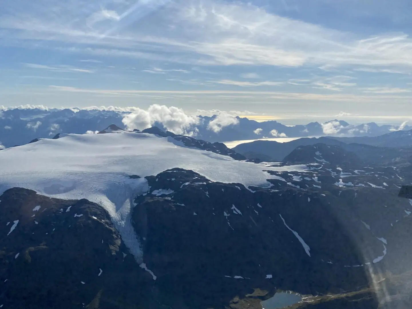 An aerial view of a glacier with mountains in the background.