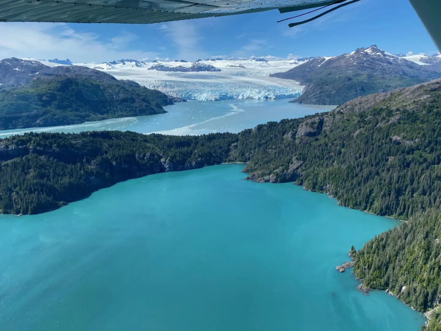 An aerial view of a glacier and a blue lake.