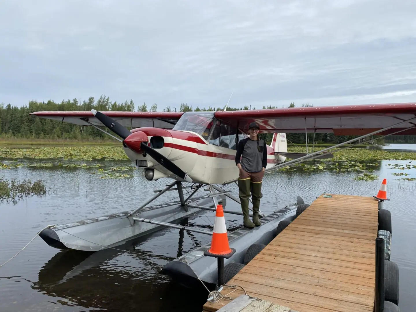 A man standing next to a plane on a dock.