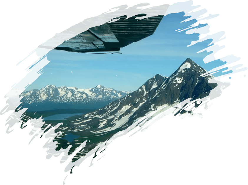 A plane flying over a mountain range with snow capped mountains in the background.