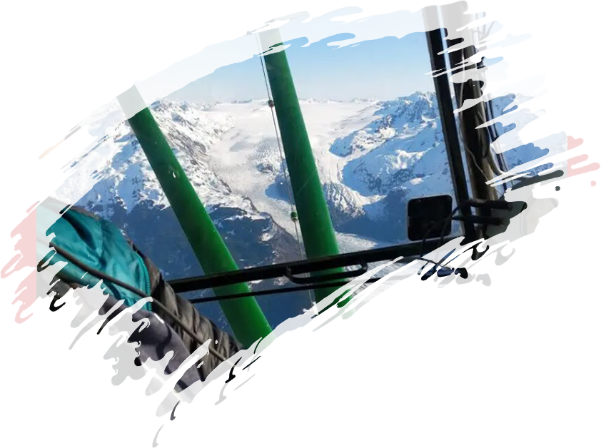 A view from the cockpit of a helicopter with mountains in the background.