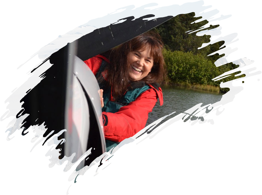 A woman smiling out of the window of a boat.